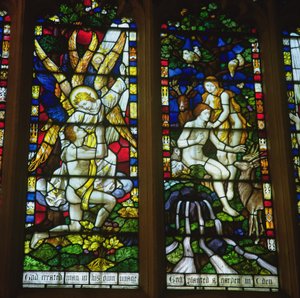 Stained glass windows depicting The Annunciation and Adam and Eve in the Garden of Eden